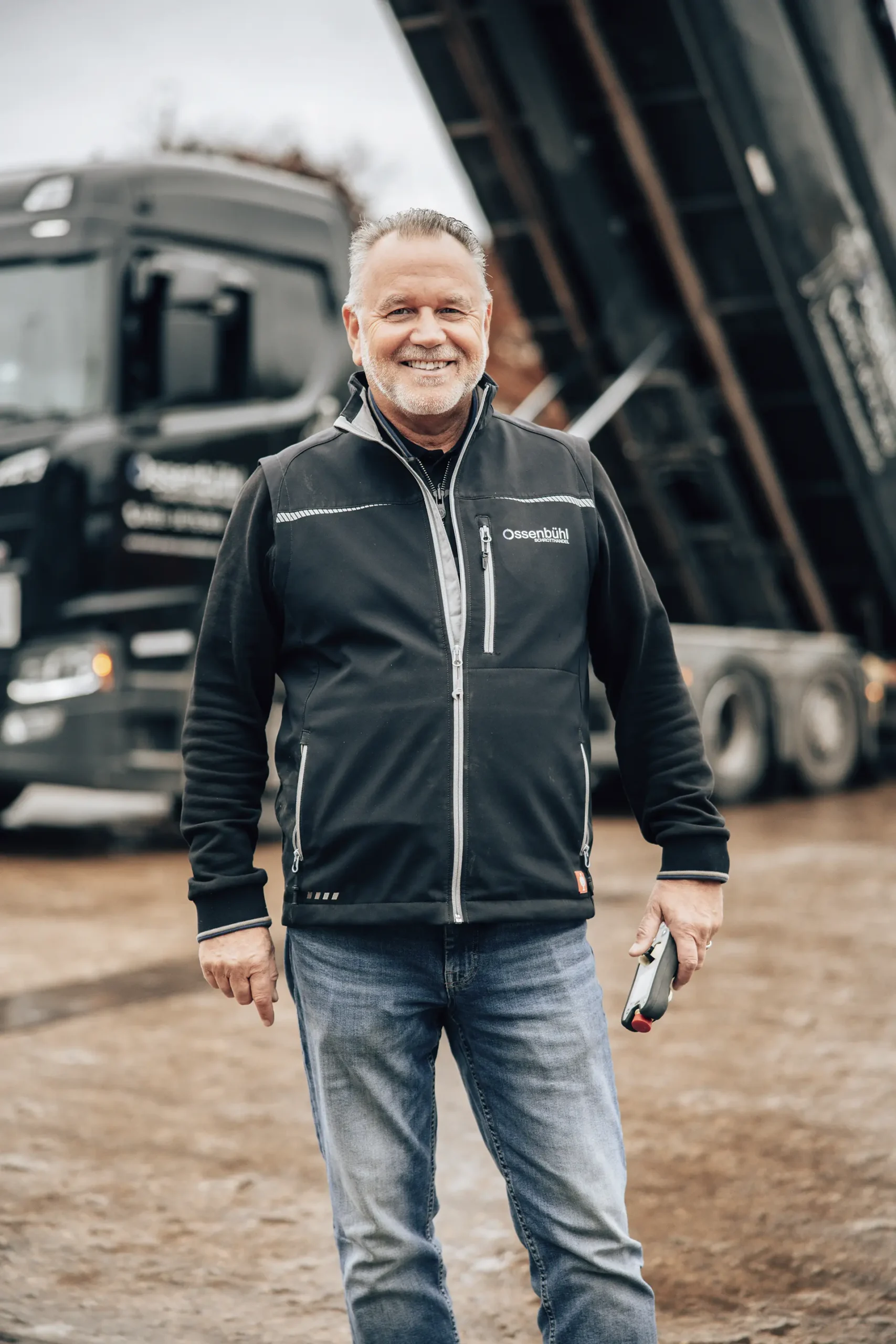 Schrotthandel Düsseldorf Ossenbühl Mitarbeiter vor Containerfahrzeug beim Abkippen scaled